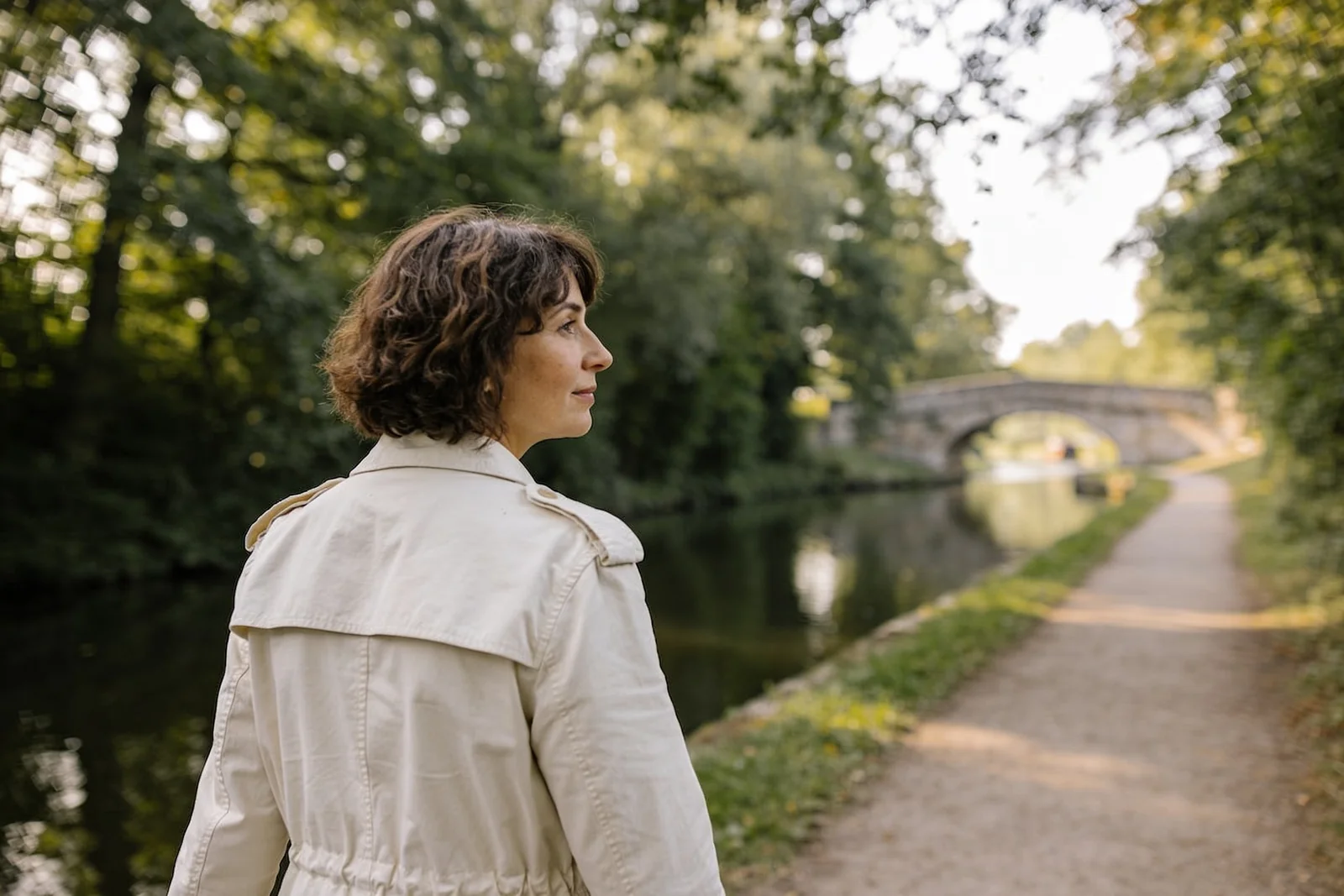 A person walking outdoors along a quiet path on a calm day